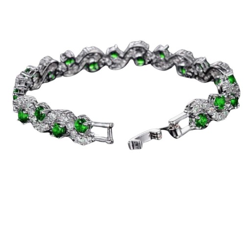 A beautiful silver bracelet with emerald green crystals and clear crystals set in a wavy pattern.