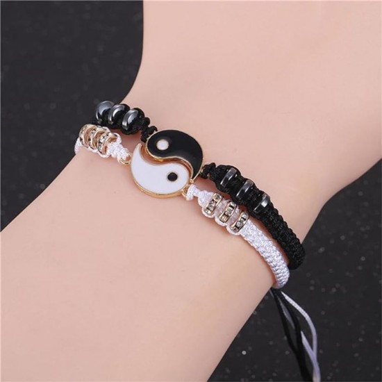A photo of two yin yang charm bracelets. One bracelet is black with a white yin charm, and the other bracelet is white with a black yang charm. Best Friend Black and White Yin Yang Charm Bracelets-Gold|image