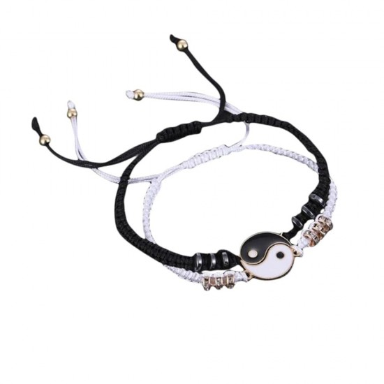 A photo of two yin yang charm bracelets. One bracelet is black with a white yin charm, and the other bracelet is white with a black yang charm. Best Friend Black and White Yin Yang Charm Bracelets-Gold|image