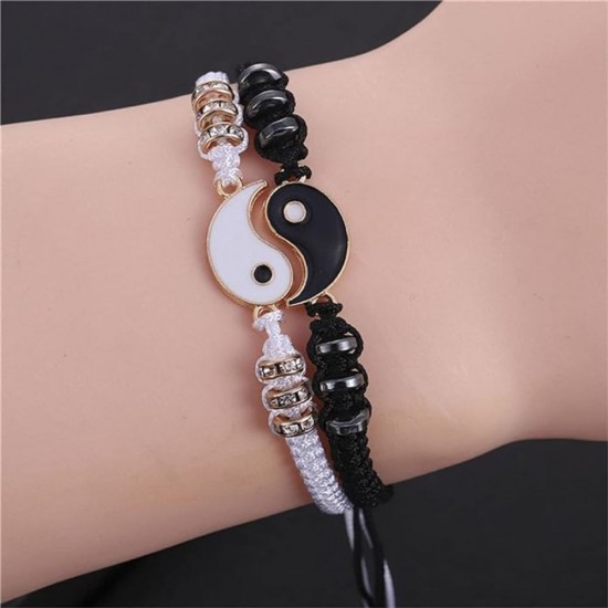 A photo of two yin yang charm bracelets. One bracelet is black with a white yin charm, and the other bracelet is white with a black yang charm. Best Friend Black and White Yin Yang Charm Bracelets-Gold|image