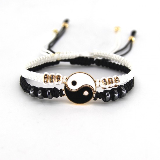 A photo of two yin yang charm bracelets. One bracelet is black with a white yin charm, and the other bracelet is white with a black yang charm. Best Friend Black and White Yin Yang Charm Bracelets-Gold|image