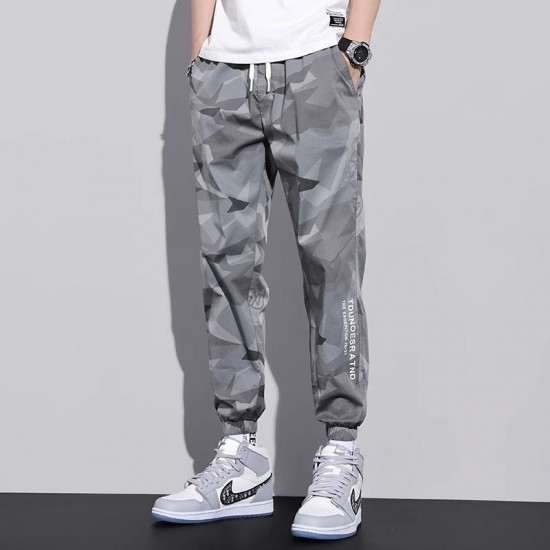Men's wearing relaxed-fit camouflage sweatpants with multiple pockets, lounging comfortably in a UAE setting. Men's Camo Sweatpants With Multi Pockets-Grey |image
