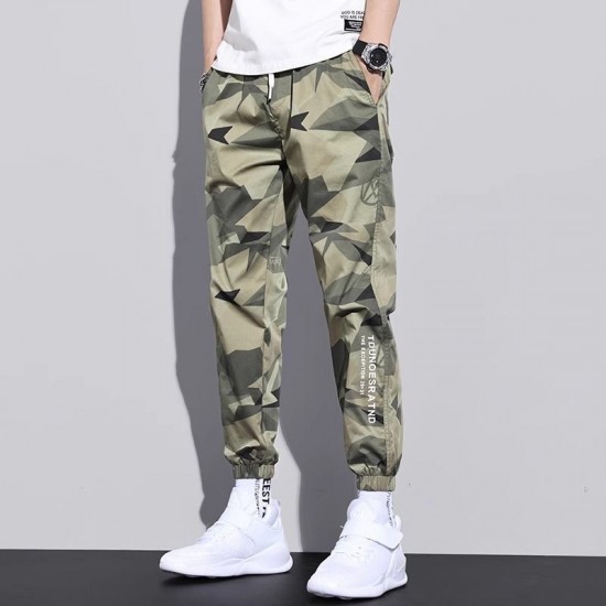 Men's wearing relaxed-fit camouflage sweatpants with multiple pockets, lounging comfortably in a UAE setting. Men's Camo Sweatpants With Multi Pockets-Green |image