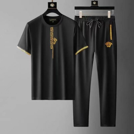 Men's Black Versace tracksuit modeled on a man, featuring a gold medusa logo embroidered on the chest. Luxury Style Men's Black & Gold Tracksuit |image